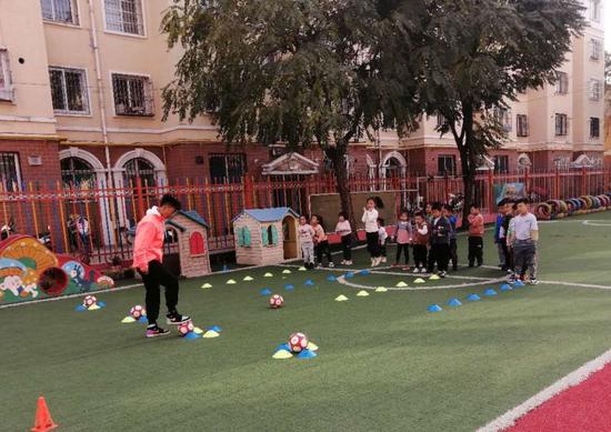 图为恒利俱乐部教练员吴军强去到平罗县星海花园幼儿园，免费为学生上足球训练课。