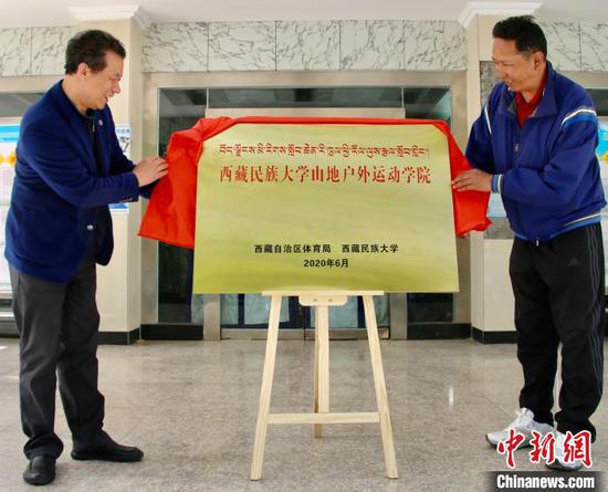  图为6月1日，西藏自治区体育局局长尼玛次仁（右）与西藏民族大学校长刘凯共同为“西藏民族大学登山户外运动学院”揭牌。　次仁旦达　摄