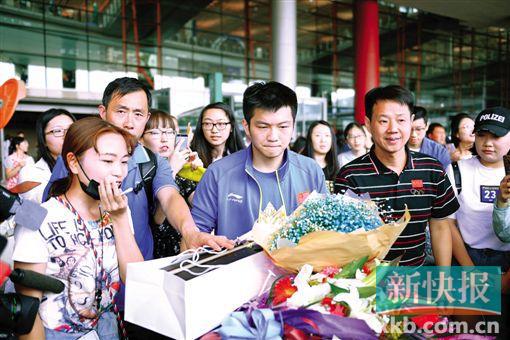 ■球迷迎接中国乒乓球队回国。小胖樊振东收到的花里,“混入”了一只烧鸡。CFP/图