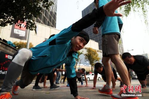 一群健身爱好者在教练的带领下进行户外野练。（资料图，中新社记者 汤彦俊 摄）