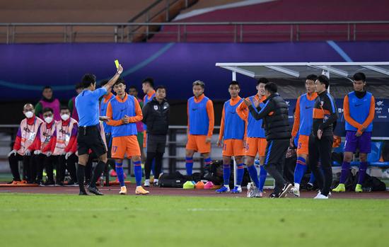  10月22日，主裁判金希坤（前左一）在比赛中向山东鲁能泰山队替补球员出示黄牌。新华社记者 许畅 摄