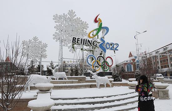 行人在河北省崇礼区街头拍摄雪景