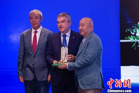 国际奥委会主席巴赫（中）向中国著名画家、“为奥运喝彩”项目艺术总顾问范扬（右）颁发顾拜旦奖章。供图