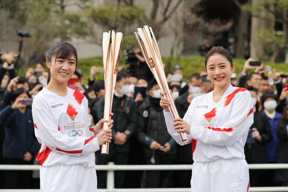 2月15日，东京奥运会圣火传递大使石原里美（右）与临时担任“火炬手”的工作人员在演练传递圣火。新华社记者杜潇逸摄