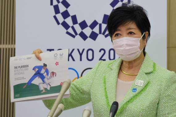 4月28日，东京都知事小池百合子展示针对运动员及官员的防疫手册。新华社/法新