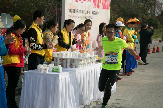 参赛选手经过补给点时补充水分