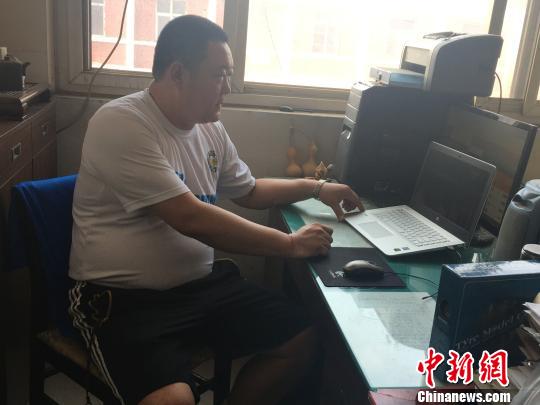 图为杨耀观看丁霞比赛的视频。　李洋　摄