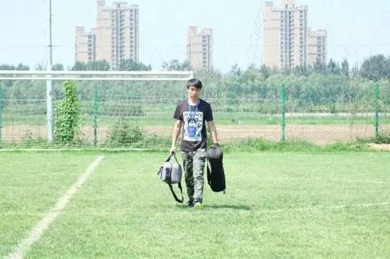 搜达足球工作人员在烈日下进场准备11岁精英赛赛事拍摄工作。