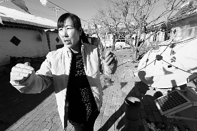 刘素英向记者展示如何用院子里的仪器测量降雪量