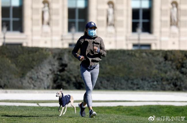 图为3月23日拍摄到的一名全副武装的女性和狗狗在跑步。