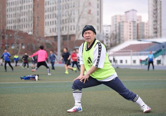 3月31日，在北京交通大学体育场，高洪光在踢球前做热身活动。