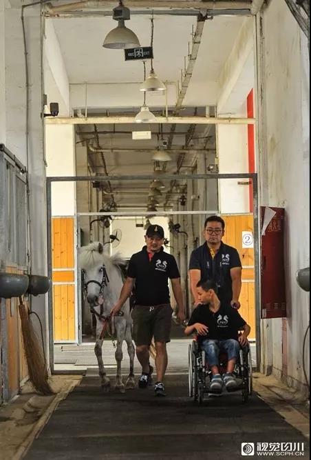 教练赵冀川牵着马,带队员去训练场地