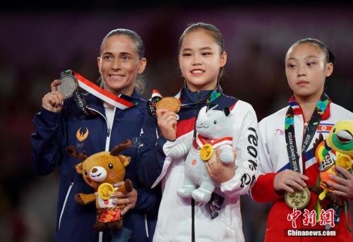 丘索维金娜(左)与获得冠军的韩国小选手、获得第三名的朝鲜小选手在颁奖仪式上合影。中新社记者 侯宇 摄