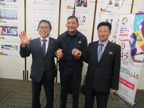 亚洲奥林匹克理事会相关人士与大韩体育会秘书长全忠烈（左）、朝鲜体育副相元吉友（右）牵手合影。