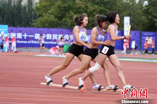 膝盖处缠着绷带，于溪淼和队友奋力冲向终点。　卢键　摄