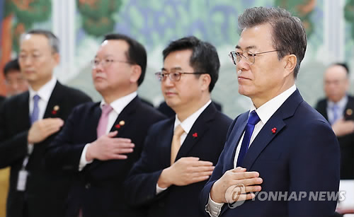 1月2日，在青瓦台，韩国总统文在寅（右一）在新年首场国务会议前向国旗敬礼。