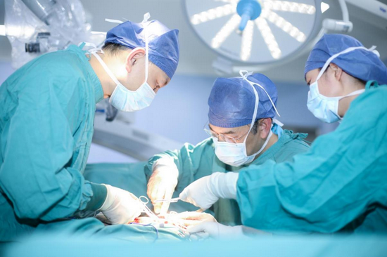 整形医院颌面外科主任籍建华(左)与整形外科主任王爱武(中)为患者手术