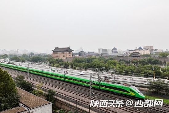 2022年10月1日,一列从西安站发车的“复兴号”动集动车组驶过城墙。(刘翔 摄)