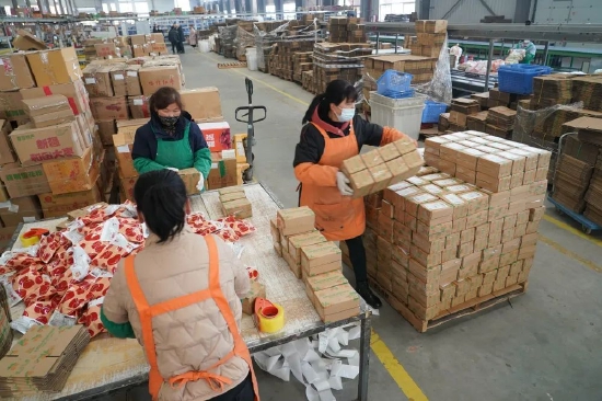 2月6日,陕西美农网络科技有限公司的工人在物流仓内打包食品快递包裹。(新华社记者 邵瑞 摄)