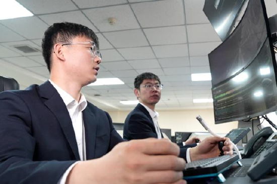 图为高鹏和鲁毛毛操控太空舱远程割煤