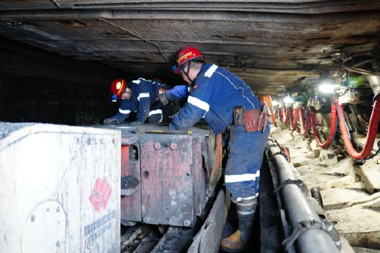 图为检修工在薄煤层工作面作业