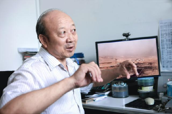 图为刘会祥给记者介绍神东矿区旧貌