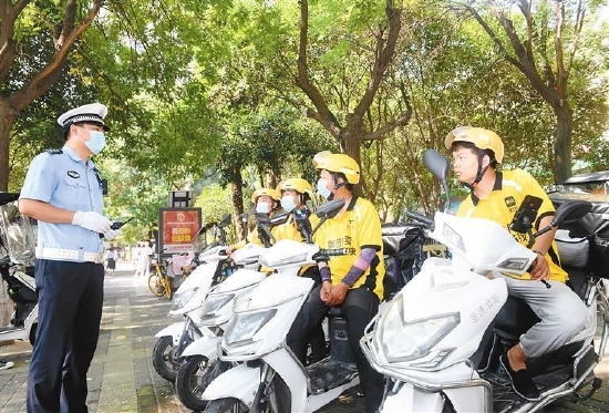 图为交警给外卖员讲解道路安全知识