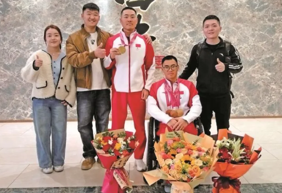 3月18日，在西安北站，陕西籍越野滑雪和冬季两项运动员刘子旭（右二）、王涛（右三）载誉归来。