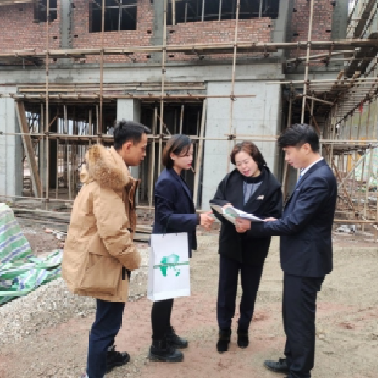 图：工作人员走村入户普及金融保险知识