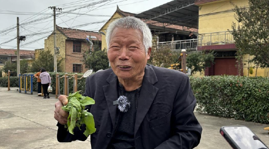 图为宋彬老人，他每天都会拿烂菜叶在地上写唐诗。