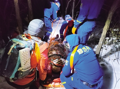 救援人员抬伤员下山