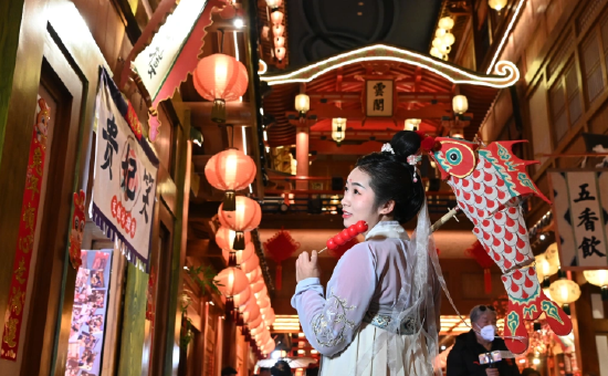 身穿传统服饰的游客在西安“长安十二时辰”主题街区里游玩(2023年1月24日摄)。新华社记者 刘潇 摄