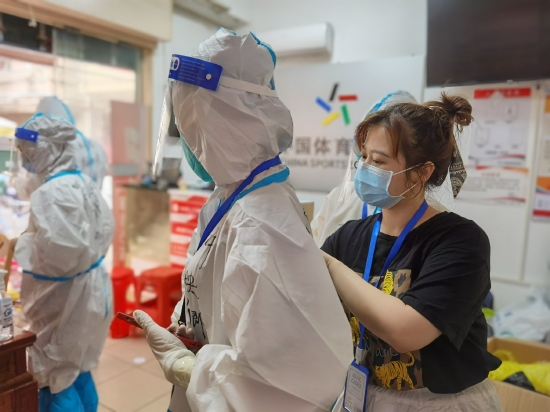 志愿者在体彩店内穿戴防护服