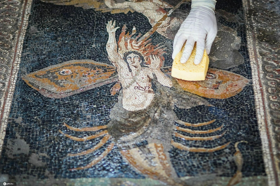 年8月6日,意大利庞贝,一名工人在重新开放的thermopolium清洗马赛克