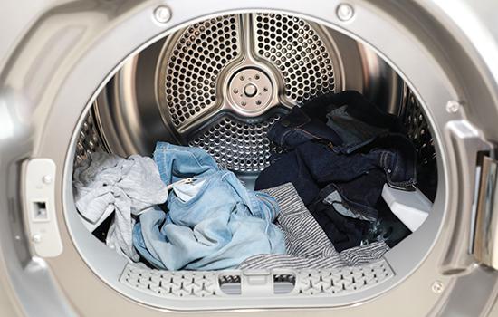 将洗涤甩干后的衣物放入干衣机