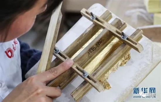 切箔：工匠用竹刀将金箔切成标准尺寸。图片来源：新华社/记者杨磊摄