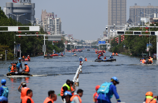 7月27日，在积水严重的卫辉城区，救援人员在搜救被困群众。新华社记者 李嘉南 摄