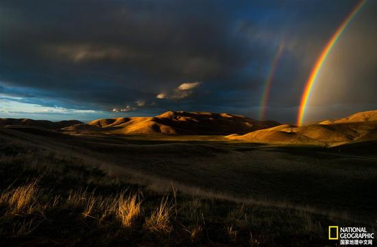 在春末的一次暴风雨期间，美丽的彩虹高悬于加州圣埃米迪奥山脉的上空。圣埃米迪奥山区是生态丰富和地质种类繁多的地区，也是风车洞的所在地。摄影：DEVLIN GANDY
