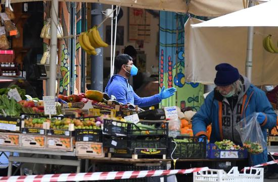 4月2日，在意大利首都罗马，人们戴着口罩在市场购买蔬果。新华社发（埃丽萨·林格利亚摄）