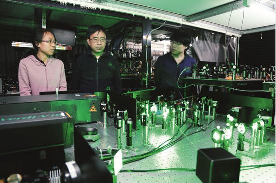 潘建伟（左二）在中国科学技术大学一实验室内了解科研情况。图/受访者提供