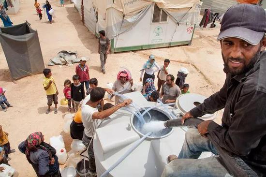 难民在叙利亚边境的一个营地取水，摄于2015年。图片来源：Ashley Gilbertson/VII for UNICEF/Redux/eyevine