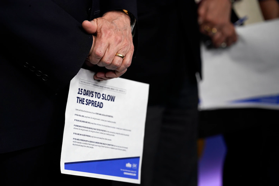  副总统彭斯周一在与冠状病毒特别工作组的新闻发布会上拿着一张信息表。(Evan Vucci / 美联社)