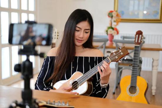 主播在拍摄乐器教学视频。/图虫创意