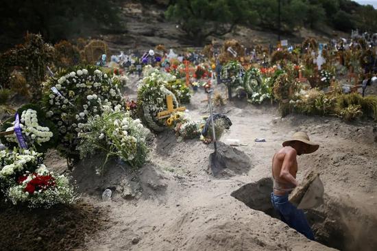 疫情仍在继续，一名工人正在墨西哥城附近的墓地里挖墓坑。来源：Edgard Garrido/Reuters