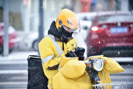 一名外卖员正冒雪送餐