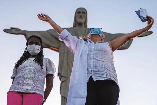 1月18日，巴西正式在全国开始新冠疫苗接种。在巴西里约热内卢，一家福利院的80岁老人特雷济尼亚·达孔塞桑（左一）和59岁护士杜尔西内亚·达席尔瓦·洛佩斯（右二），在接种中国北京科兴中维生物技术有限公司研发的新冠疫苗克尔来福后庆祝。图/人民视觉