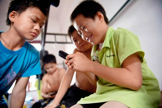 湖南长沙的一群孩子们在玩手机游戏 （李锋摄 视觉中国供图）