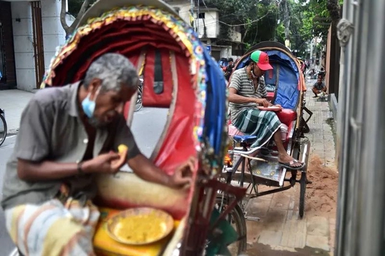 孟加拉国达卡，人力车司机正短暂停下吃饭。对南亚许多人来说，兼顾“地球健康”的餐食成本超出了他们的能力范围。来源：Munir Uz zaman/AFP/Getty