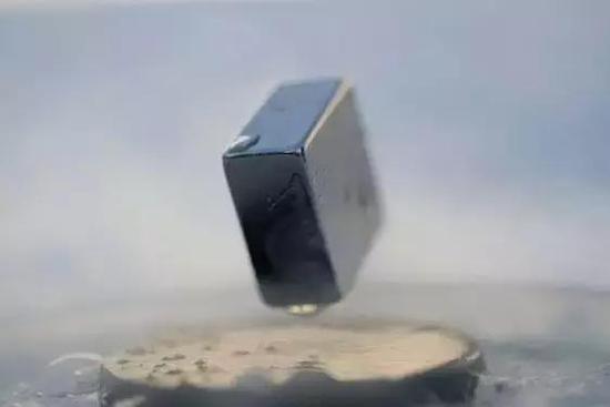图 | 一块磁铁漂浮在超导体之上（来源：Wikimedia Commons）