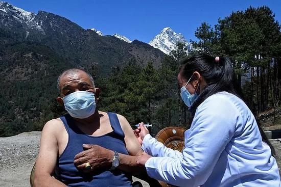 尼泊尔的一位公民在喜马拉雅山脉珠穆朗玛峰附近的卢卡拉接种新冠疫苗